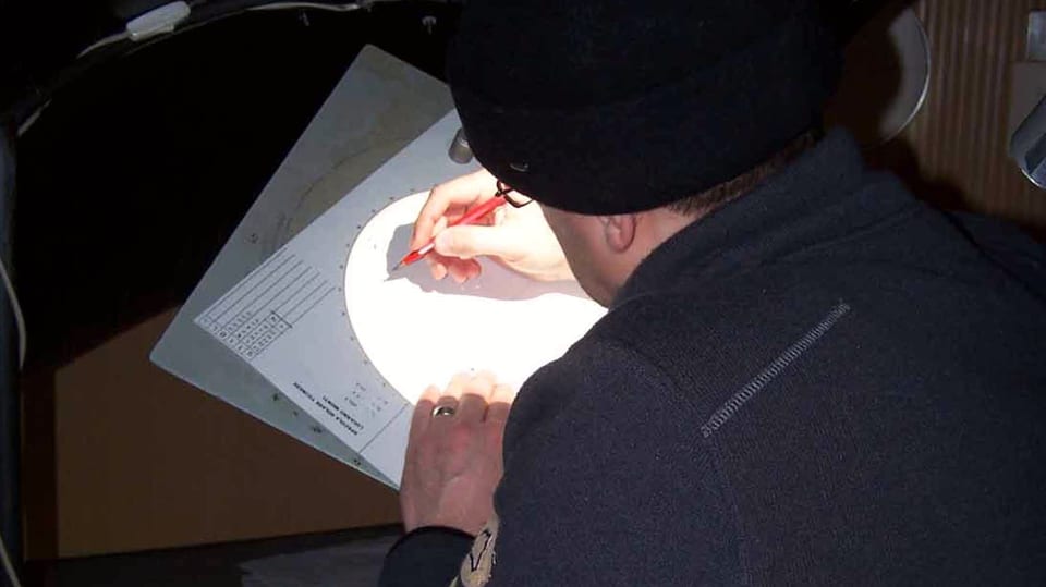 Ein Mann skizziert mit Bleistift auf einem Papier.