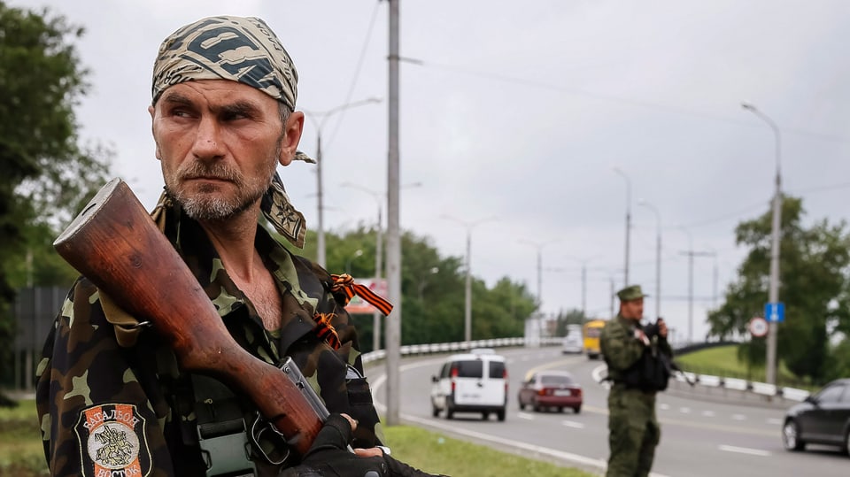 Ein pro-russischer Aufständischer sichert einen Checkpoint in Donesk. 