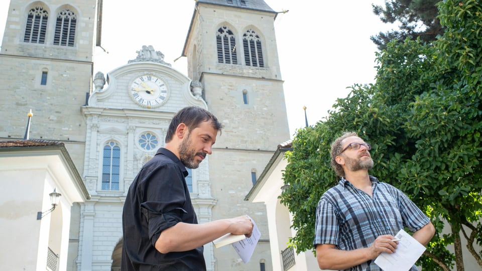 Peter Conradin Zumthor und Gabriel Schneider lauschen auf dem Platz vor der Luzerner Hofkirche dem Klang der Glocken.