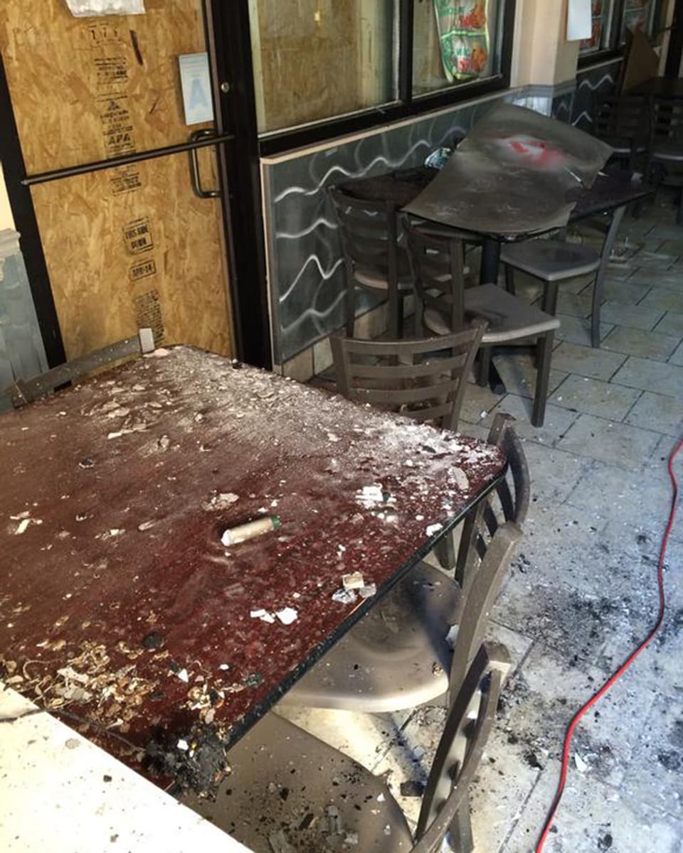 zerstörte, mit Trümmern übersähte Tische und Stühle