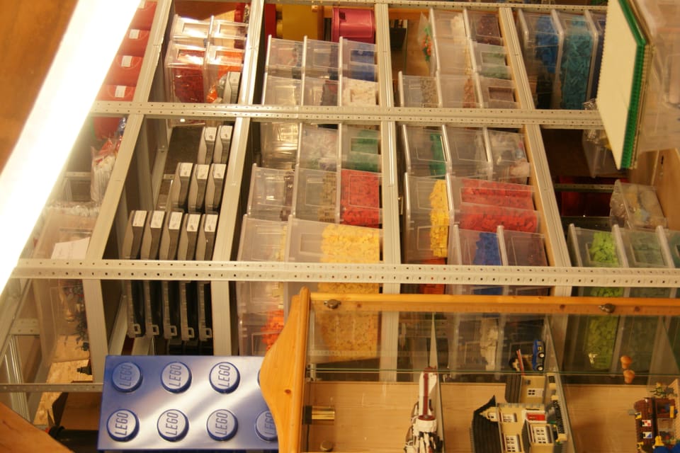 Das Bild zeigt ein Regal voller Kisten, die widerum voller Legoteilen sind.