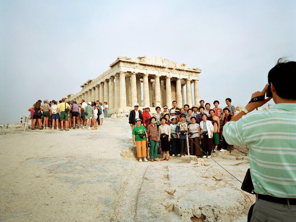 Touristen lassen sich vor der Akropolis fotografieren.