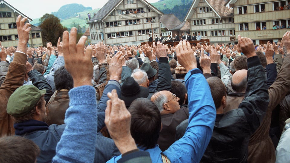 Männer erheben die Hand zur Abstimmung in Hundwil.
