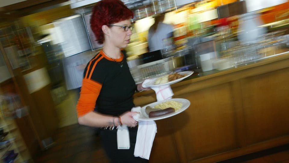Eine junge Frau serviert zwei Teller