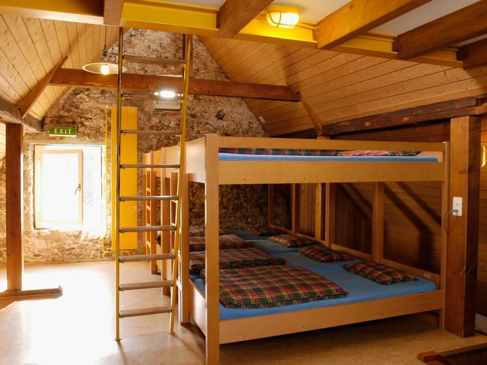 Innenansicht eines Zimmer mit Etagenbetten und Holzbalken