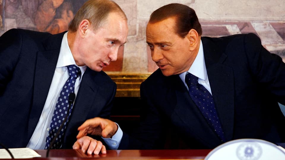 Putin und Berlusconi sprechen miteinander.