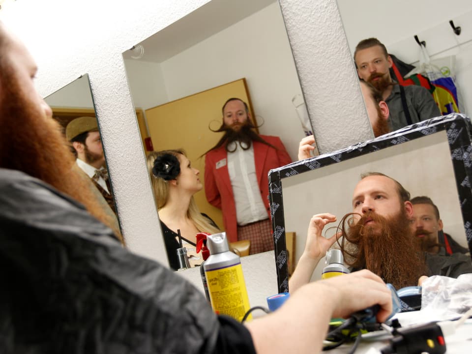 Blick in die Garderobe der WM-Teilnehmer. Ein Mann frisiert seinen Bart.