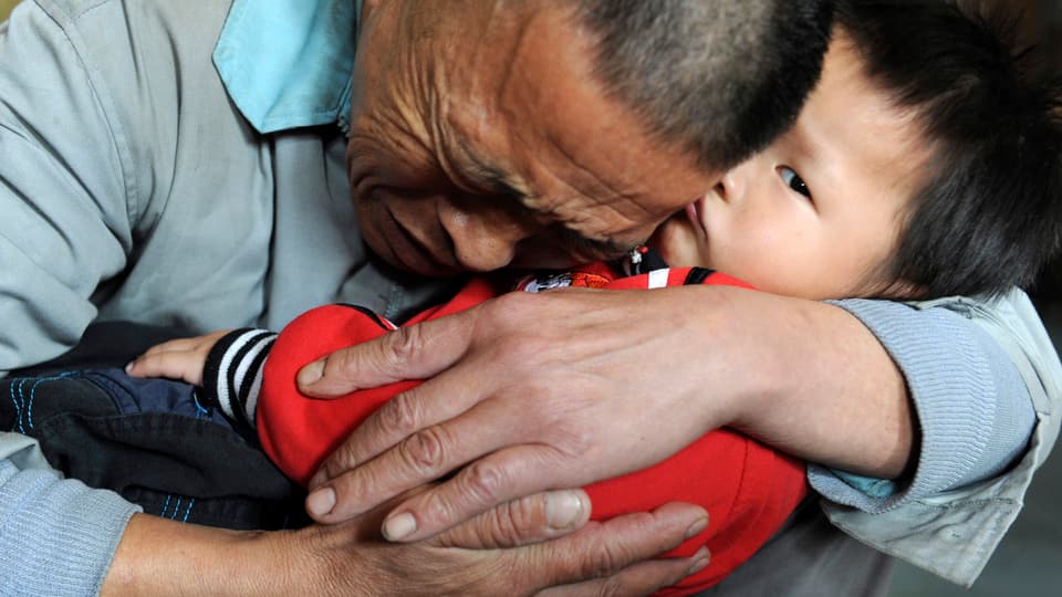 Ein Vater umarmt seinen Sohn in China.