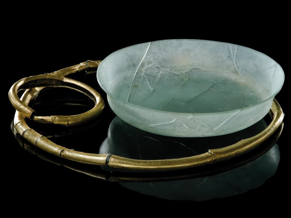 Grüne Glasschale in einem mit goldenem Ring.