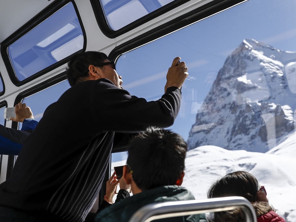 Ein chinesischer Tourist fotografiert aus dem Zug.