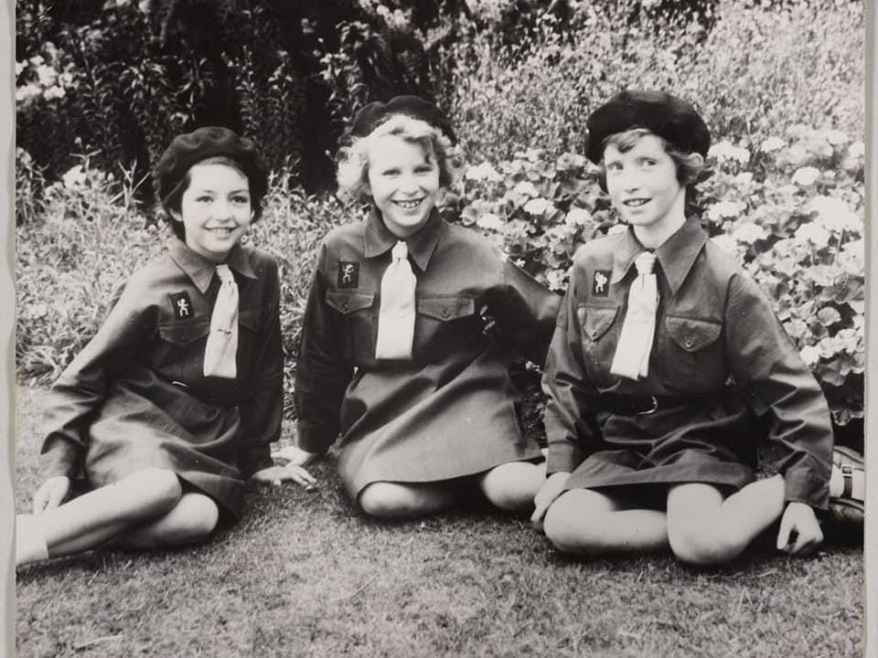 Drei Mädchen sitzen im Gras