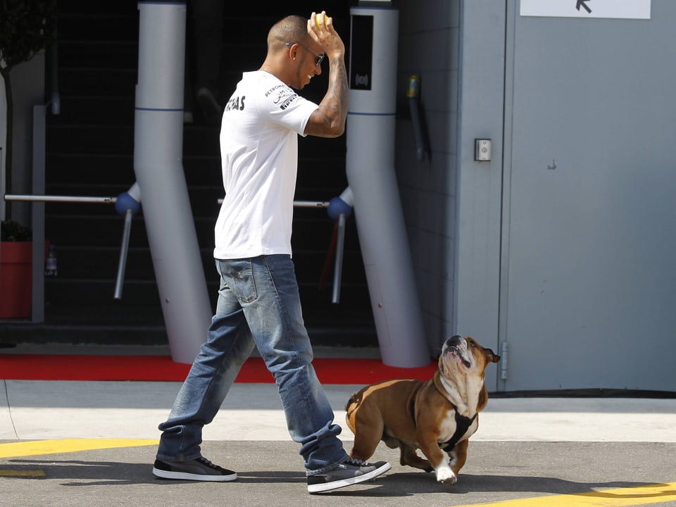 Lewis Hamilton spielt mit seinem Hund.
