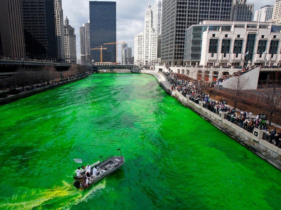 Der Chicago River leuchtet grün zwischen den Gebäuden der US-Stadt Chicago.