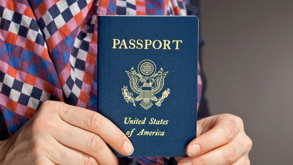 Ein US-amerikanischer Pass, in der Hand gehalten.
