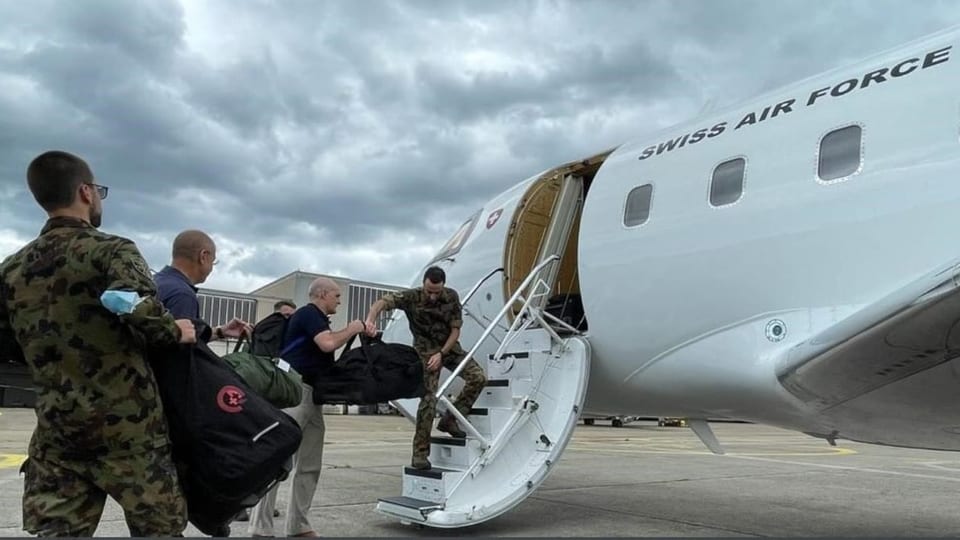 Armeeangehörige und Spezialisten steigen in ein Flugzeug