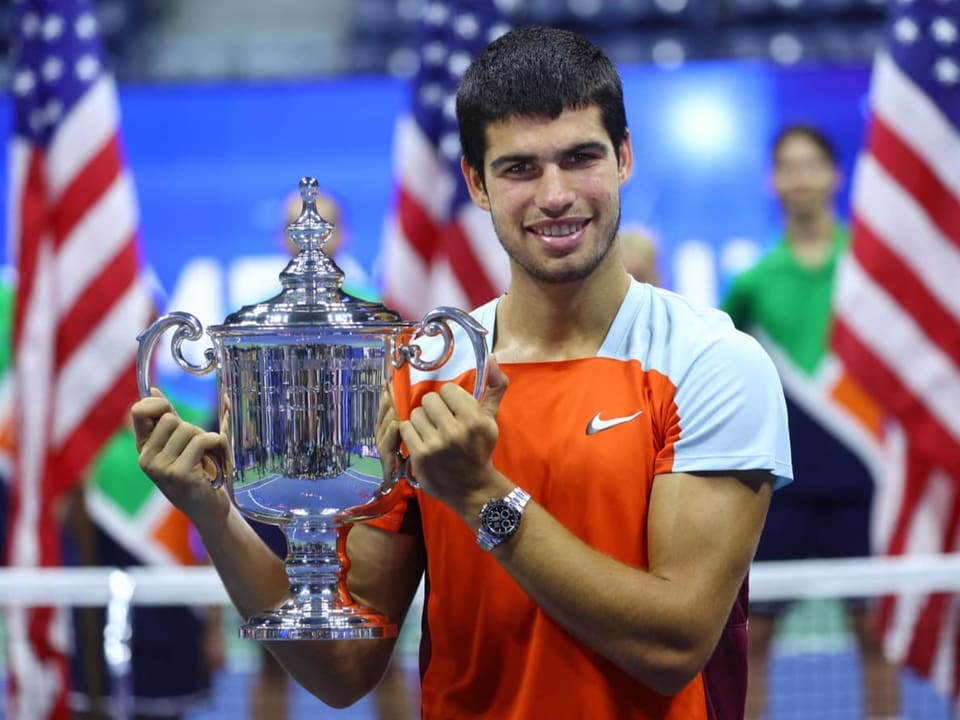 Carlos Alcaraz posiert mit der Trophäe.