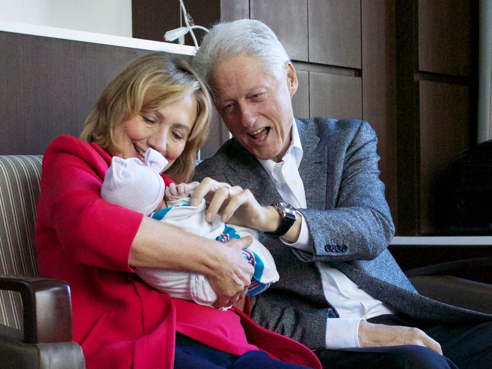 Hillary und Bill knudeln mit ihrem Enkelkind.