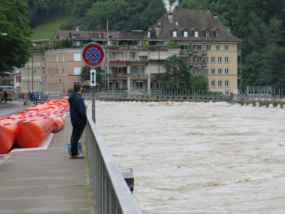 Ein Passant beobachtet die Wassermassen.