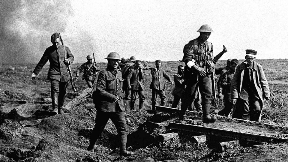 Soldaten schreiten über ein Schlachtfeld und tragen Verwundete.
