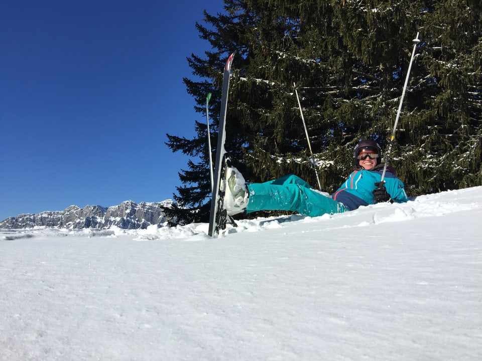 Joëlle Beeler liegt mit Skiern im Schnee.