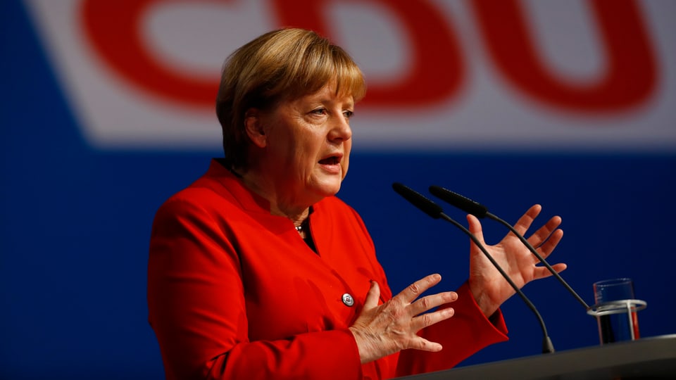 Merkel am Rednerpult vor einem grossen CDU-Logo.