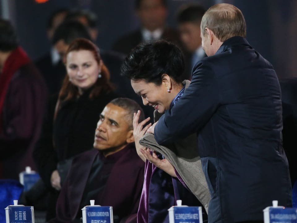 Scheiss auf die Etikette: Der russische Präsident Wladimir Putin legt der First Lady von China, Peng Liyuan, eine Wolldecke über die Schultern. Gut gemeint aber ein absolutes No-Go, einer chinesischen Frau so nahe zu kommen.