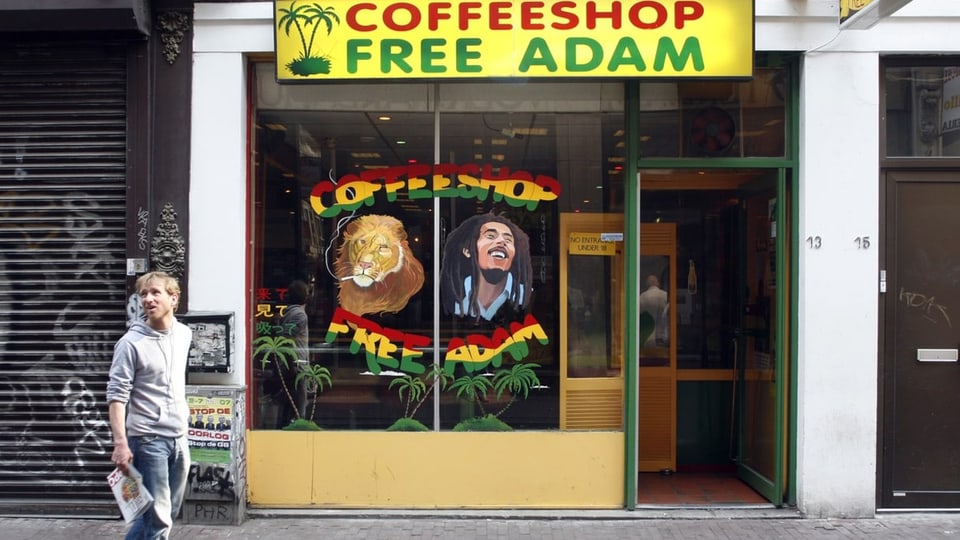 Mann läuft an Coffeeshop in Amsterdam vorbei