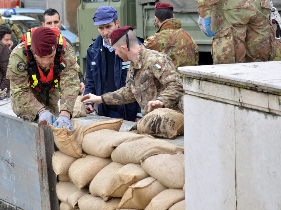 Italienische Soldaten bauen einen Schutzwall aus Sandsäcken