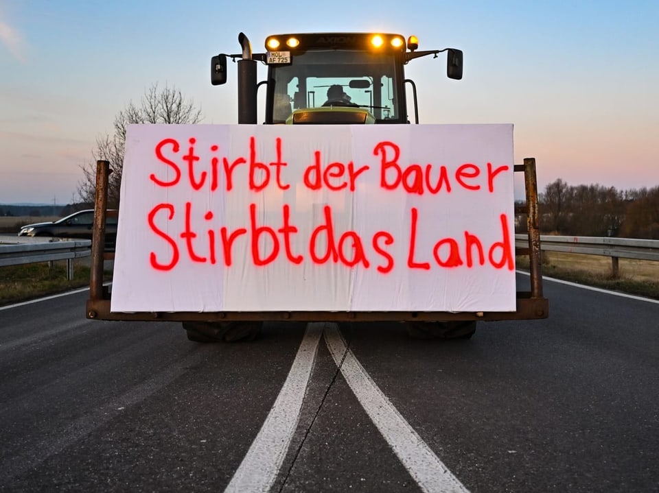 Traktor mit Plakat "Stirbt der Bauer, stirbt das Land".