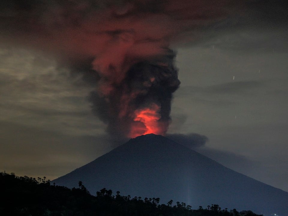 Rote Feuerwolke über dem Vulkan Agung in der Dämmerung.