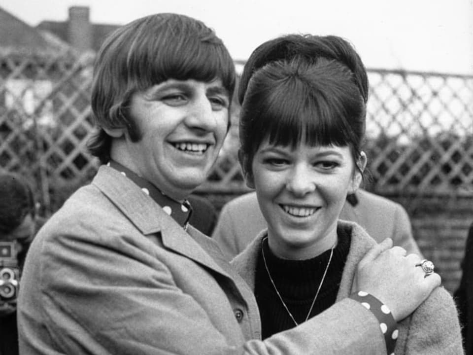 Bild von Ringo Starr und seiner erstenn Frau Maureen Cox. Es ist eine schwarz-weiss-Aufnahme, wo sich die beiden im Arm halten und lächeln.