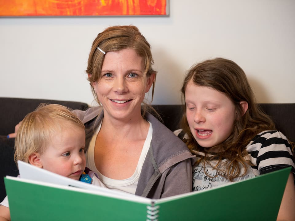 Kerstin Birkeland Ackermann auf dem Sofa mit ihren beiden Kindern Neele und Malin.