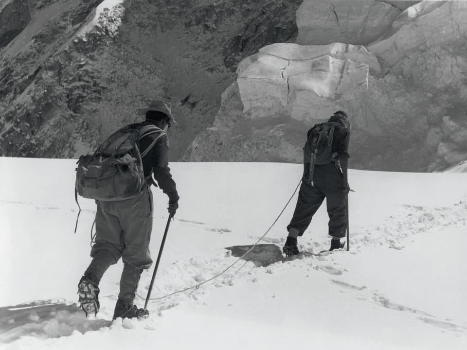 Tenzing Norgay und Edmund Hillary durchqueren ein Eisfeld am Mount Everest.