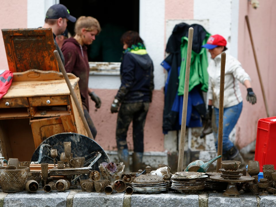 Anwohner räumen ihr Hausrat aus den verschlammten Häusern. (reuters)
