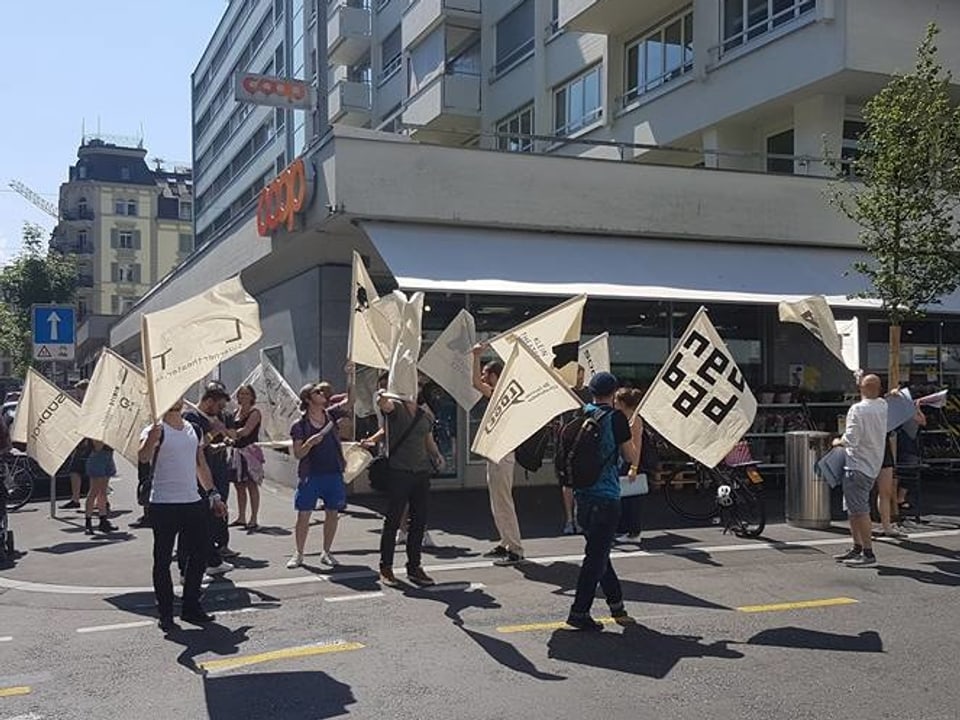 Eine Gruppe von Leuten zieht mit weissen Fahnen durch die Stadt Luzern.