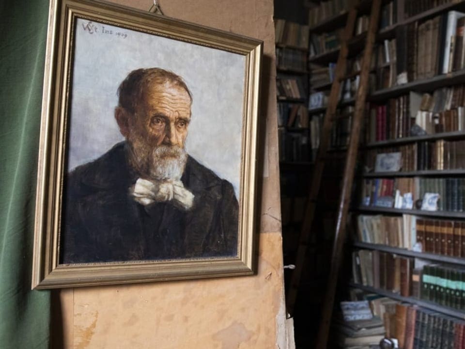 Porträt von einem älteren Mann in einem Zimmer mit einer stattlichen Bibliothek.