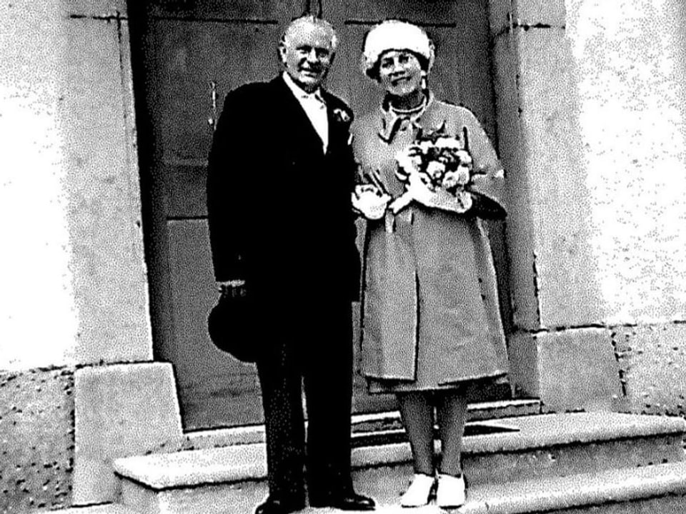 Ein Mann und eine Frau posieren vor einem Gebäude für die Kamera. Altes schwerz-weiss Foto.