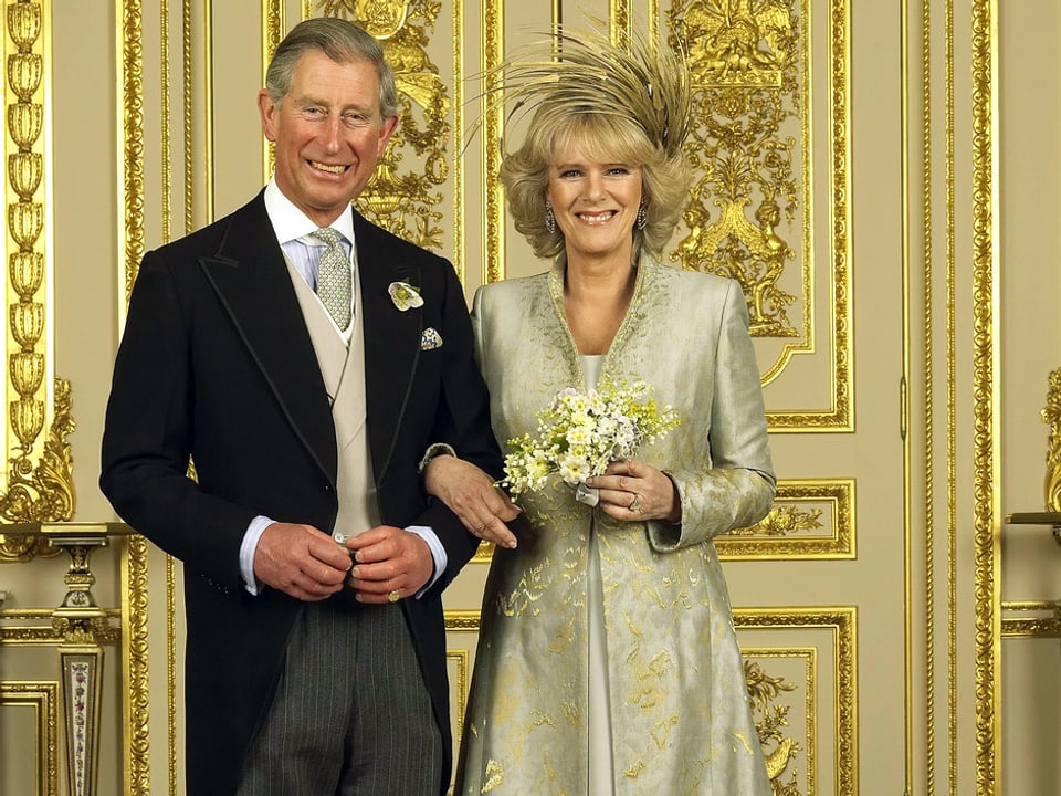 Charles und Camilla in schönen Kleidern und glücklich nach der Hochzeit in einem pompösen Saal