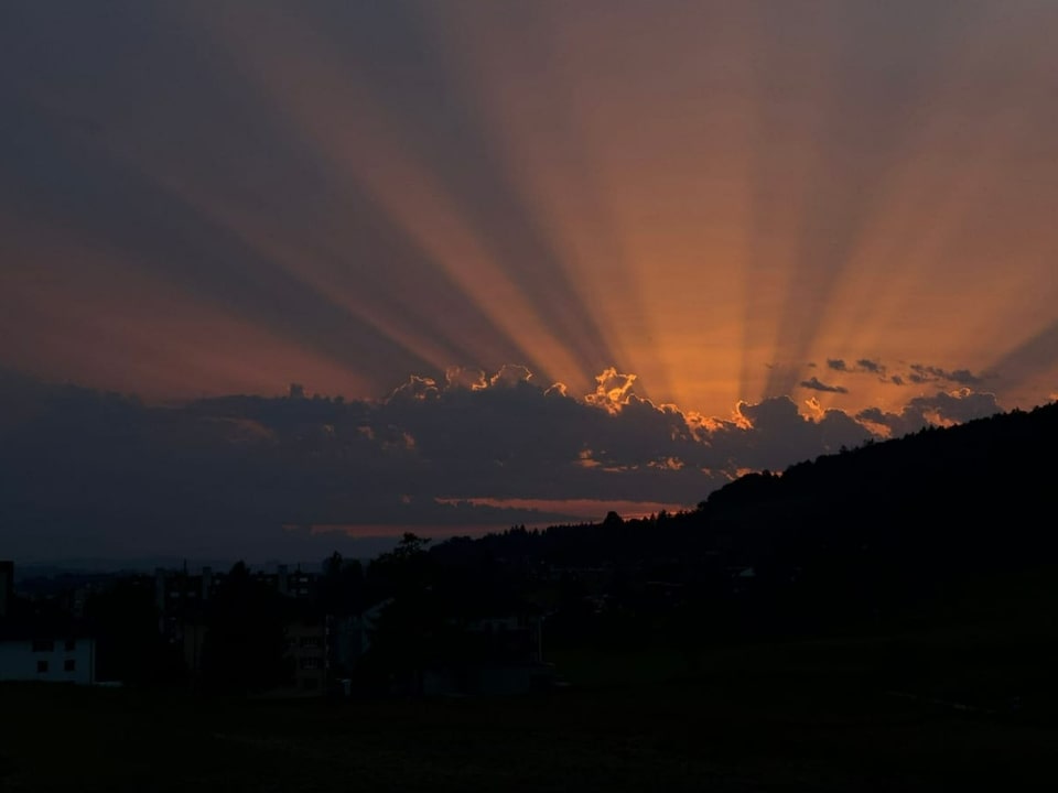 Strahlenbündel am Himmel der untergehenden Sonne.