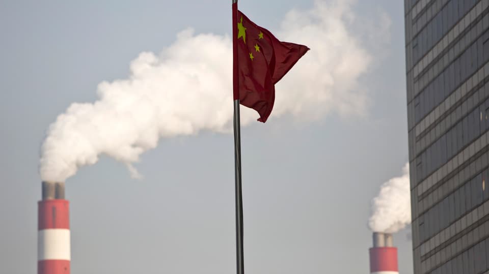 Die chinesische Flage im Vorderrgund, im Hintergrund qualmende Schornsteine.