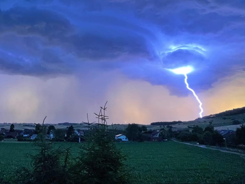 Gewitter mit Blitzeinschlag über Landschaft