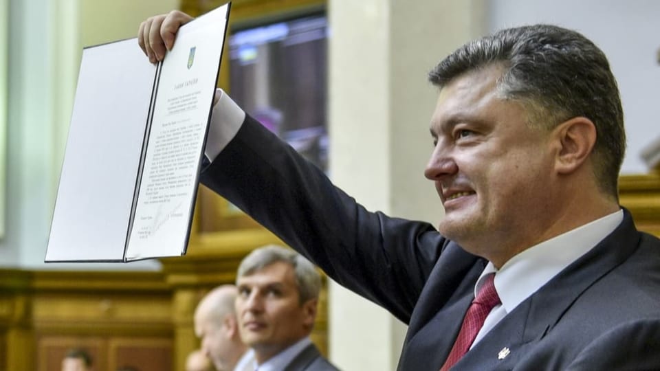 Ehemaliger ukrainischer Präsident Petro Poroschenko mit Assoziierungsabkommen in der Hand.
