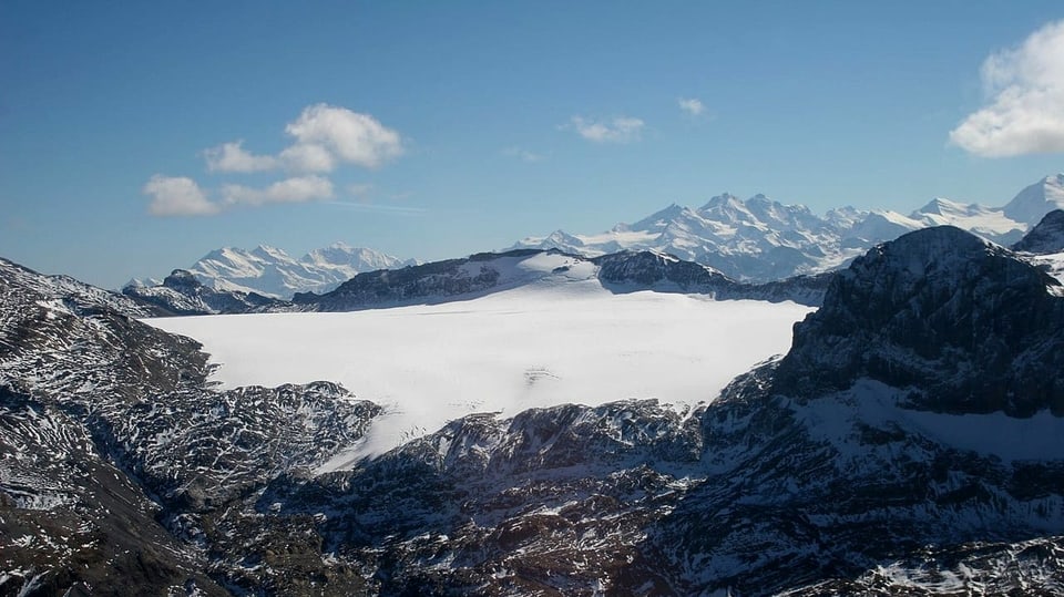 Blick auf eine Gletscherebene umgeben von Bergen.