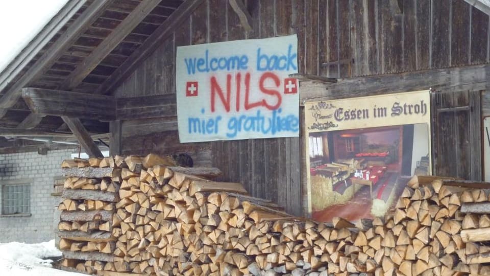 Ein Bauernhaus mit einem Banner von Nils Mani.