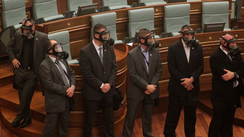Das Sicherheitspersonal im kosovarischen Parlament mit Gasmasken.