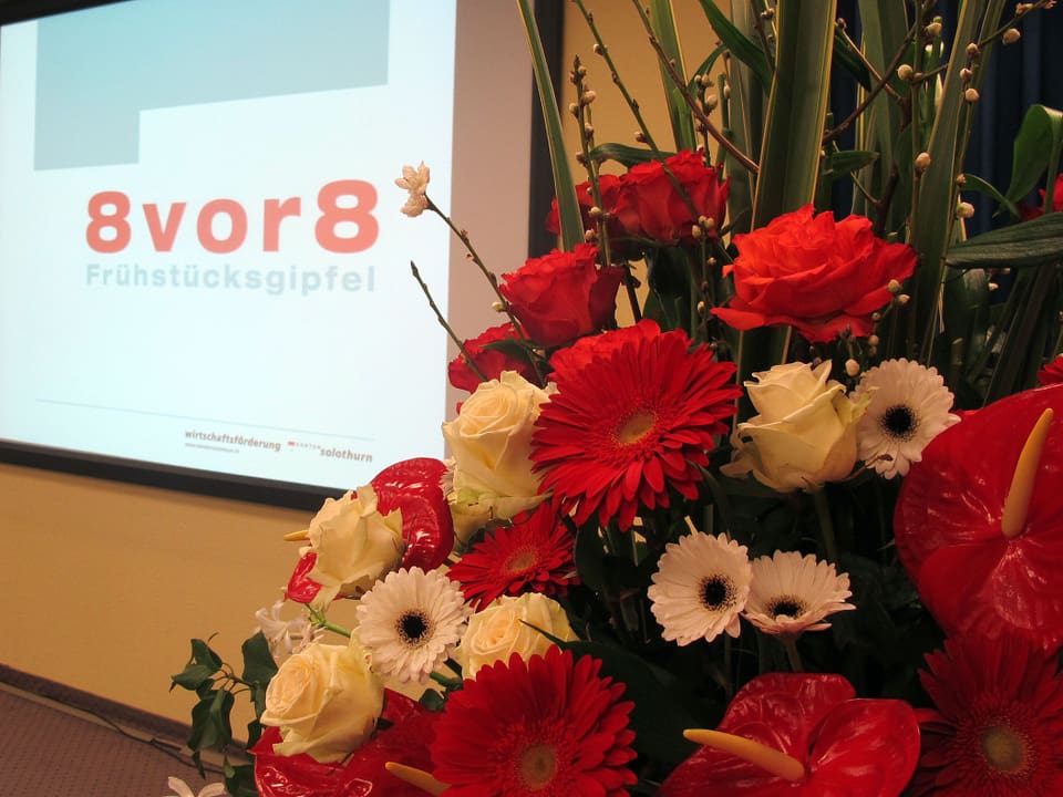Blumen und im Hintergrund Logo 8 vor 8.