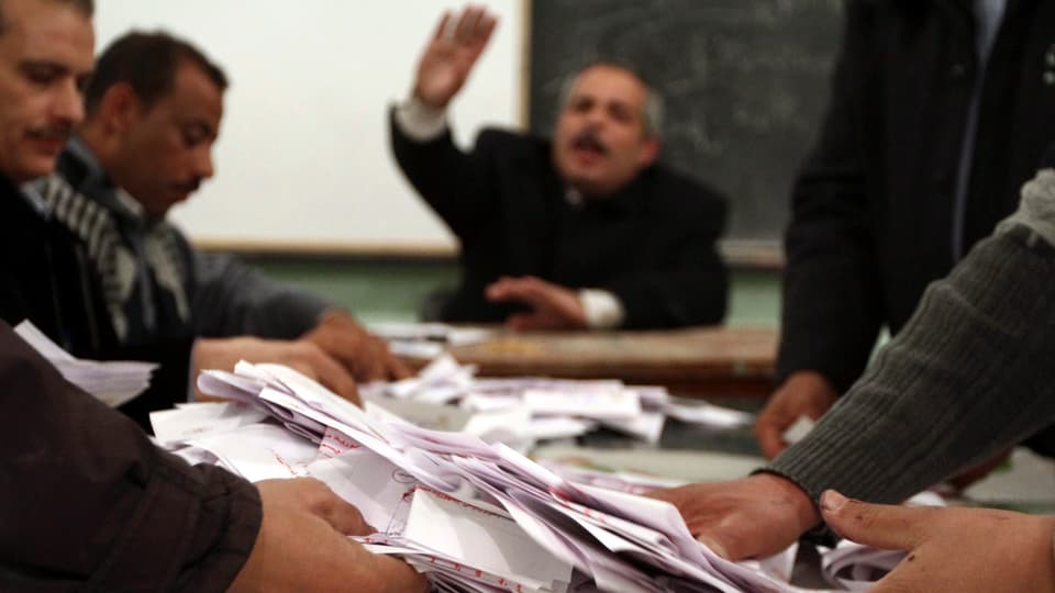 Männer sortieren Stimmzettel