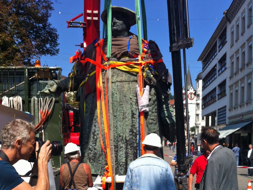 Die Vadian-Statue wird mit einer Wolldecke und Seilen am Krahn befestigt.