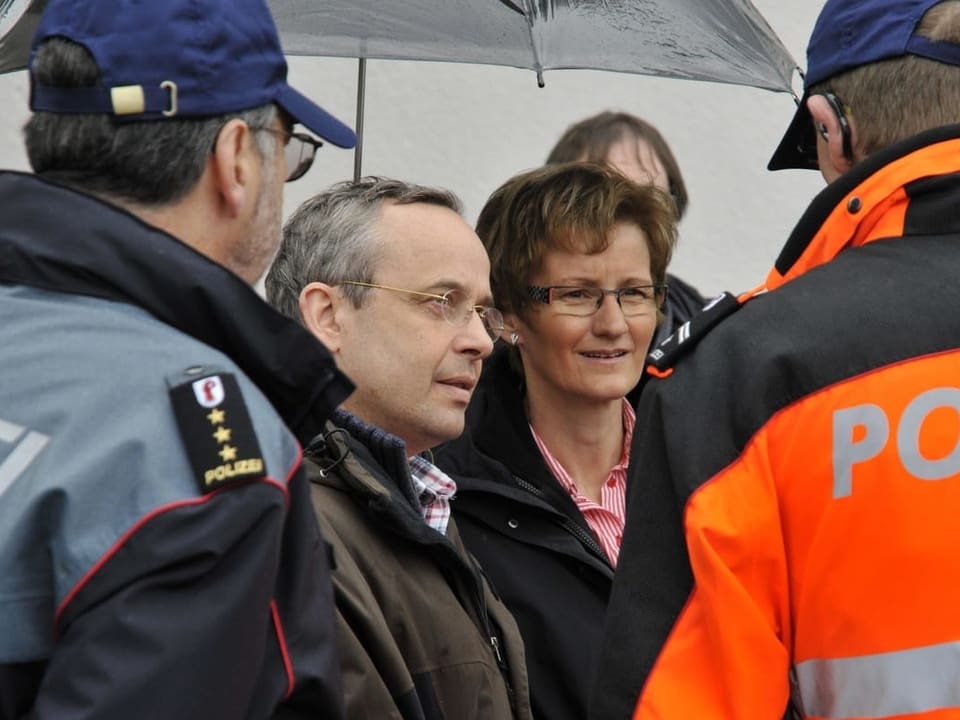 Sabine Pegoraro ist umringt von zwei Polizisten. Neben ihr steht Nationalrat Peter Malama.