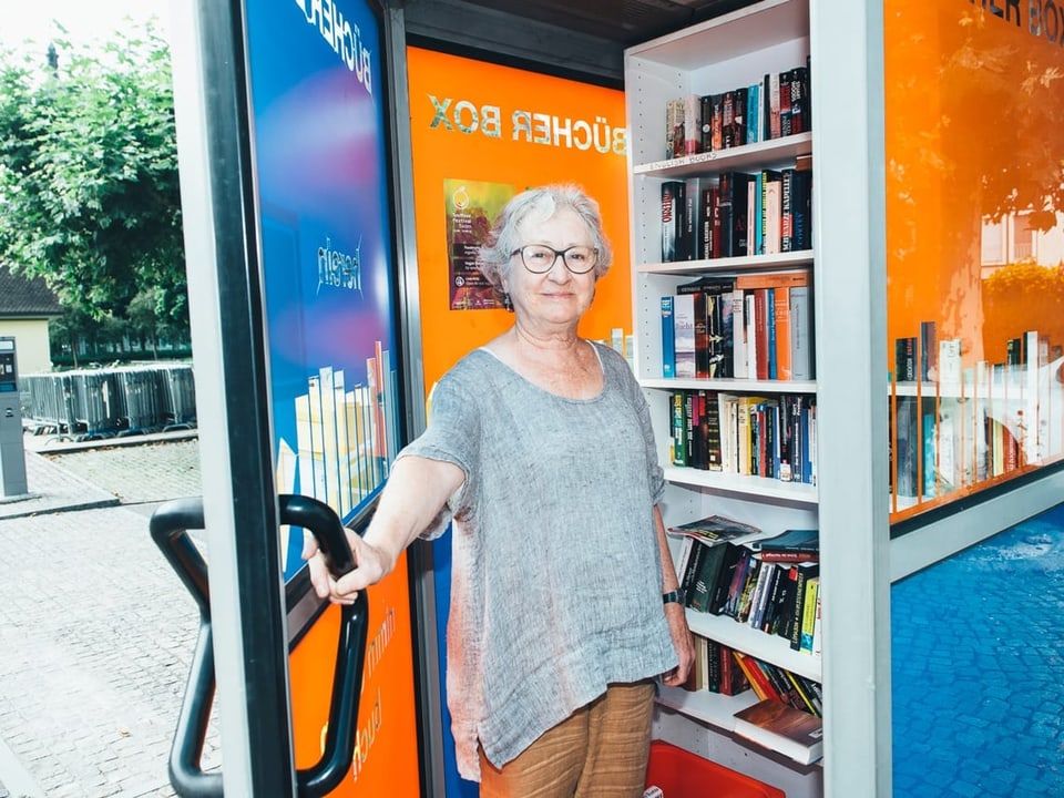«Bei uns gibt's Bücher für alle.» Frau vor Telefonzelle